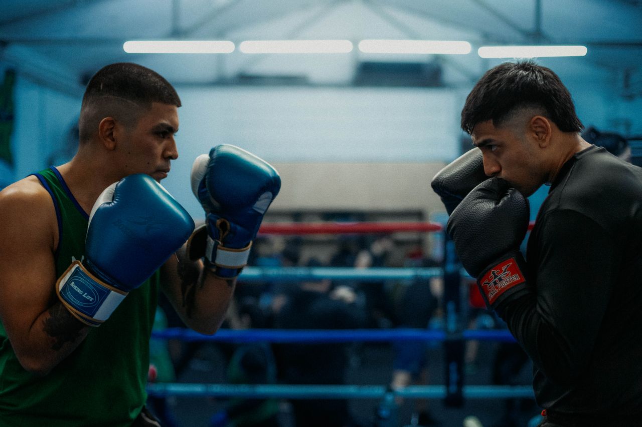 Two boxers face off in a gym in Buenos Aires, showcasing strength and focus.